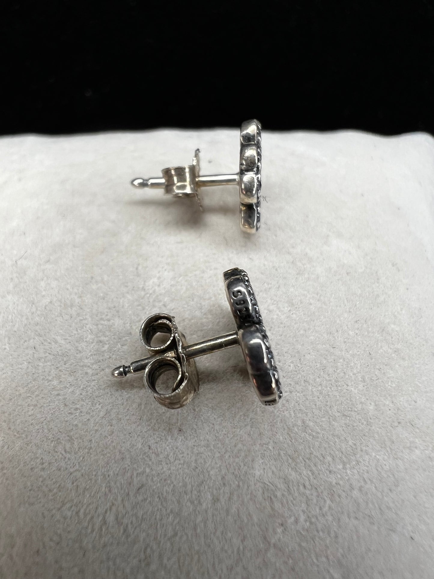 These are beautiful sterling silver earrings. They are shaped as four-leaf clovers with heart designs in each leaf and set with small clear stones throughout.