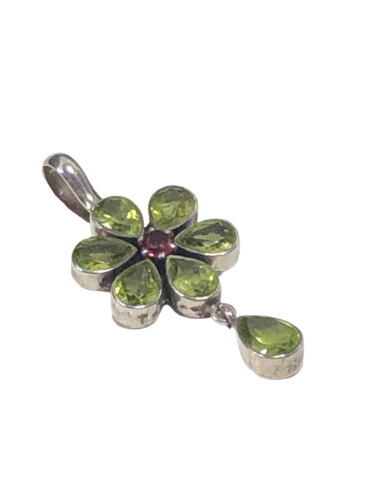 Elevate your jewelry collection with our vintage sterling silver pendant. Handcrafted in India (and signed by the silversmith), this pendant showcases a flower using peridots as petals around a pink tourmaline.