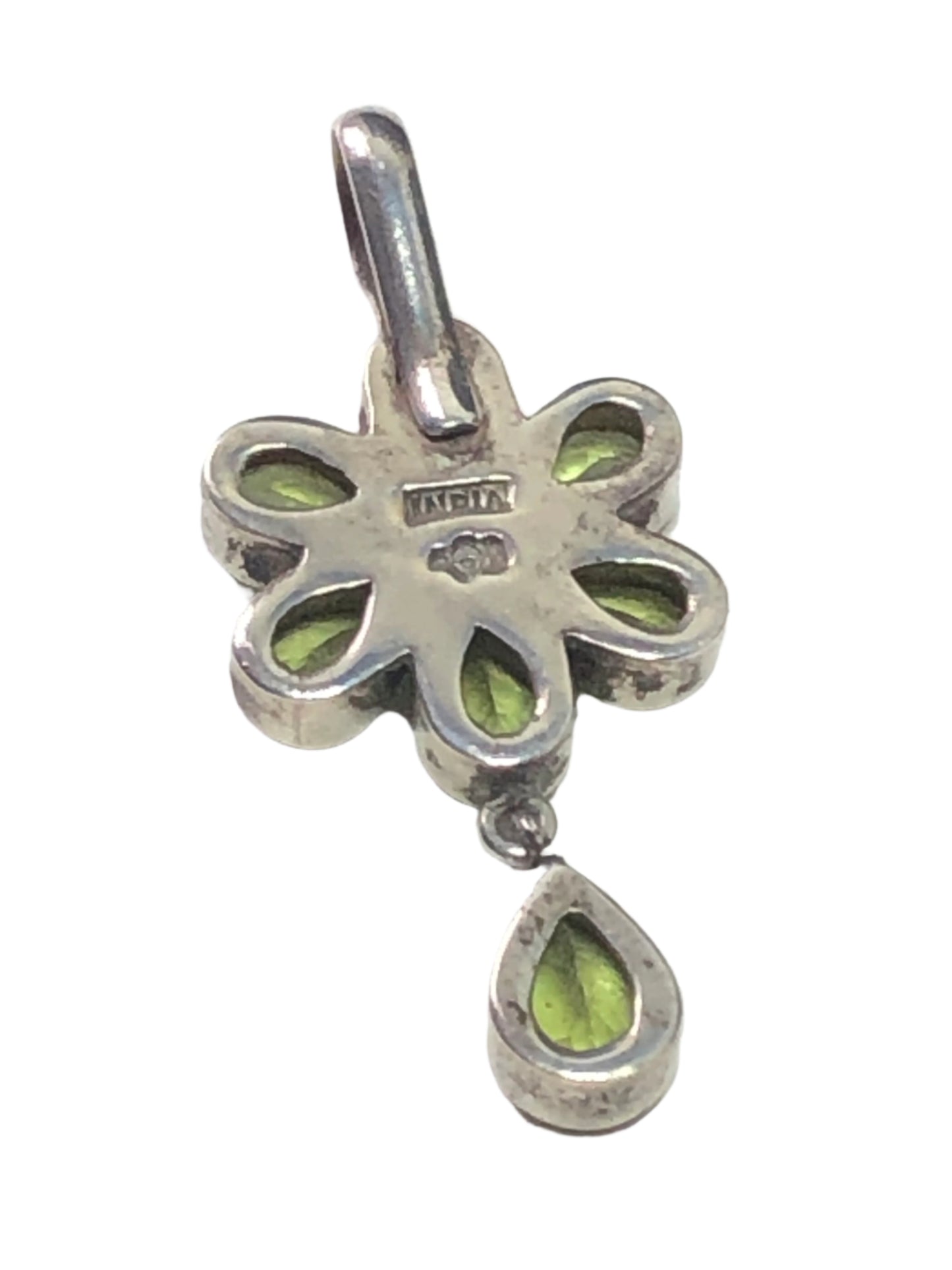 Elevate your jewelry collection with our vintage sterling silver pendant. Handcrafted in India (and signed by the silversmith), this pendant showcases a flower using peridots as petals around a pink tourmaline.