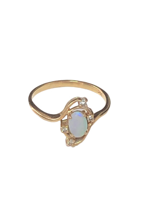 Experience luxury and elegance with our 10k gold ring. It features a shimmering opal that is complemented by small diamond accents.