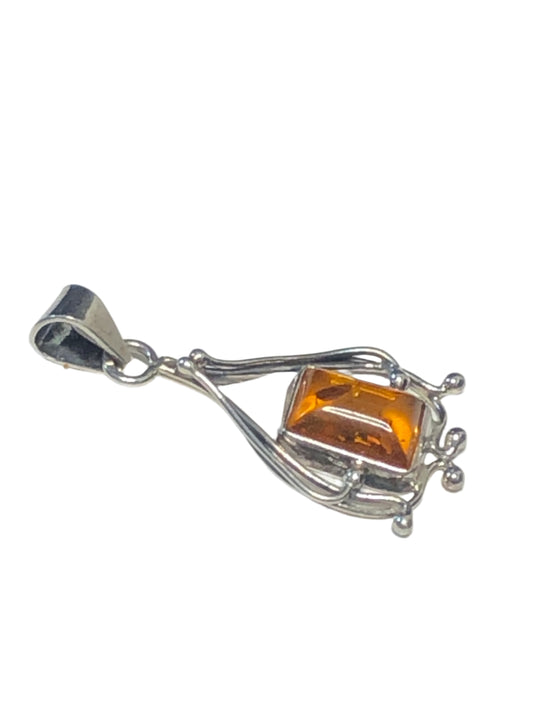 Indulge in the elegance of this vintage sterling silver pendant. It features an amber stone in a setting made with excellent craftsmanship.