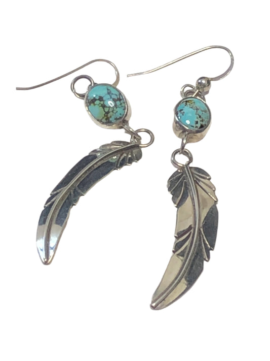 These beautiful vintage earrings feature a Native American / Southwestern design, with sterling silver feathers dangling from well-set turquoise stones.