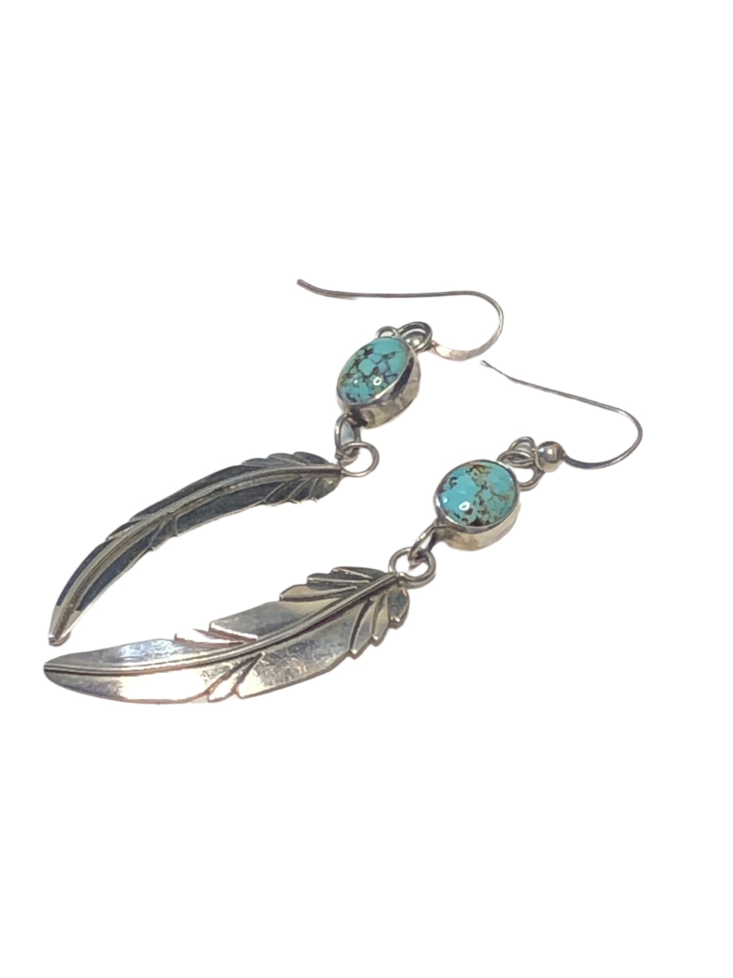 These beautiful vintage earrings feature a Native American / Southwestern design, with sterling silver feathers dangling from well-set turquoise stones.