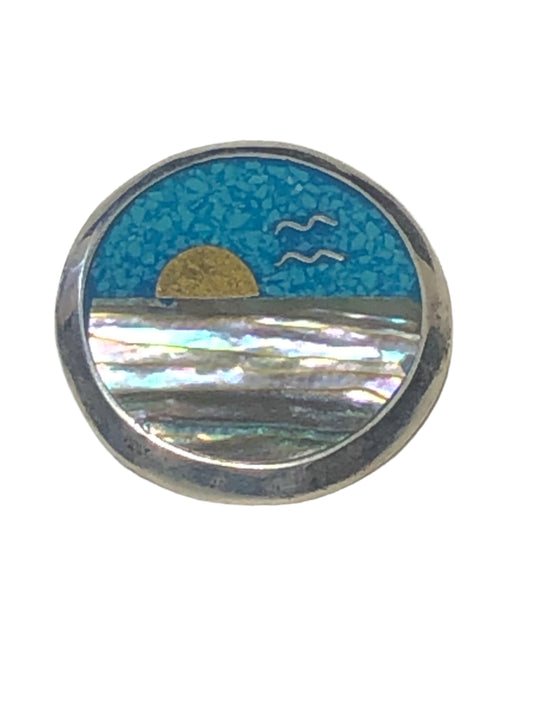 Keep a bit of sunshine close to you with this unique vintage pendant. Surrounded by sterling silver, the inlaid mother-of-pearl and turquoise chips create a vibrant sunrise scene.