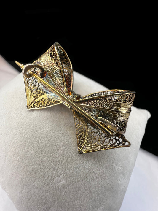 If you like antique jewelry, this filigree bow brooch is a perfect addition for your collection. It is sterling silver with a gold overlay. The nice patina and closure type date it to the late 19th century/early 20th century.