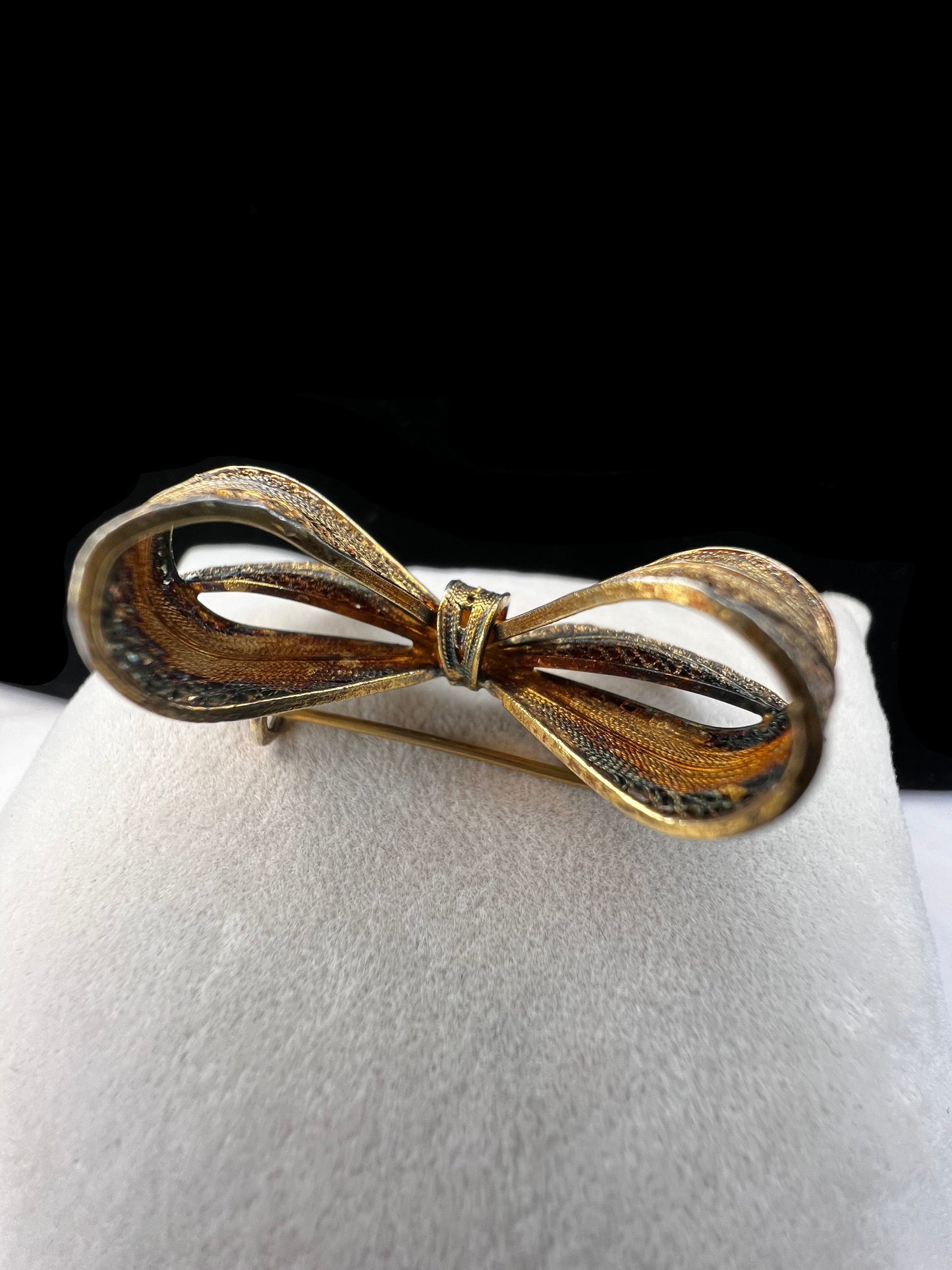 If you like antique jewelry, this filigree bow brooch is a perfect addition for your collection. It is sterling silver with a gold overlay. The nice patina and closure type date it to the late 19th century/early 20th century.