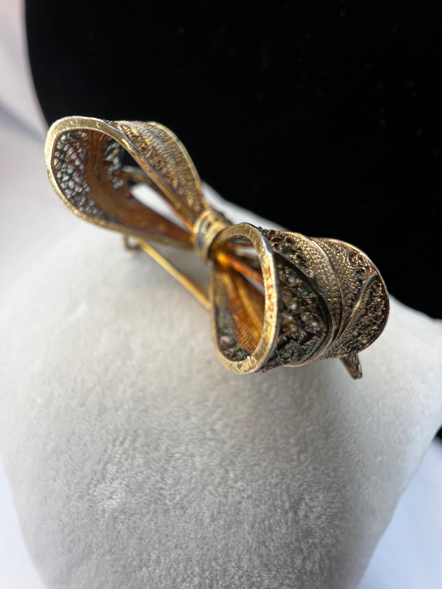 If you like antique jewelry, this filigree bow brooch is a perfect addition for your collection. It is sterling silver with a gold overlay. The nice patina and closure type date it to the late 19th century/early 20th century.