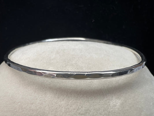 This is a sterling silver bangle bracelet with a hand-hammered finish.