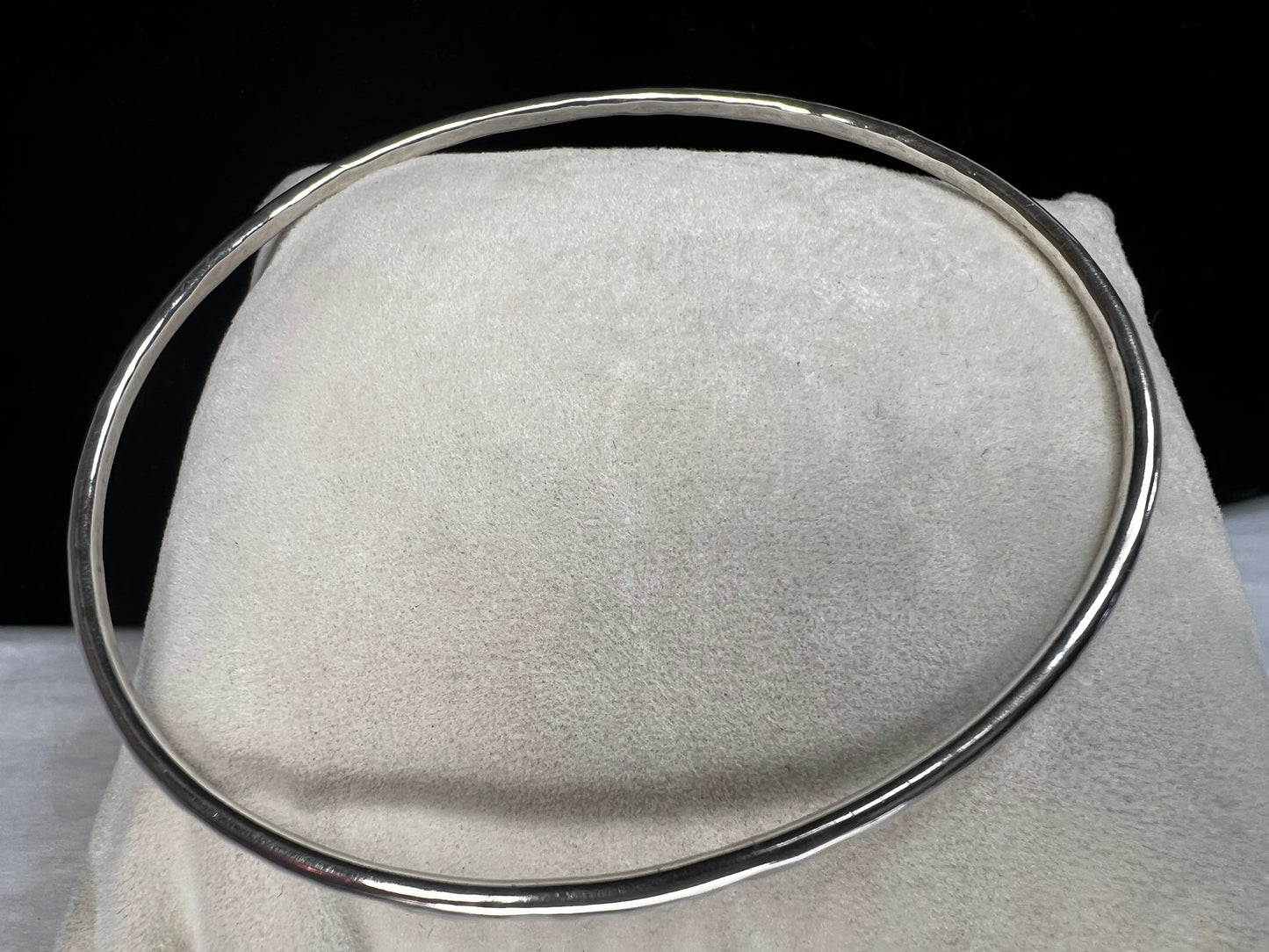 This is a sterling silver bangle bracelet with a hand-hammered finish.