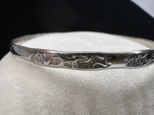 This sterling silver bangle bracelet is perfect for any outfit. It has designs around the entire outside and Mexican hallmarks on the inside.