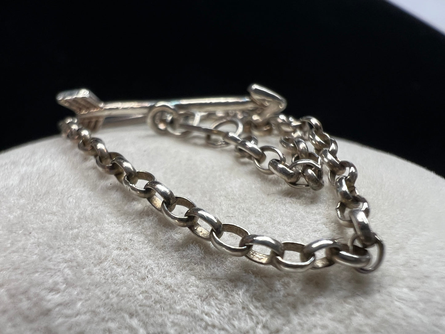 This is a petite, lovely sterling silver bracelet. The arrow goes through the heart, creating a secure closure.