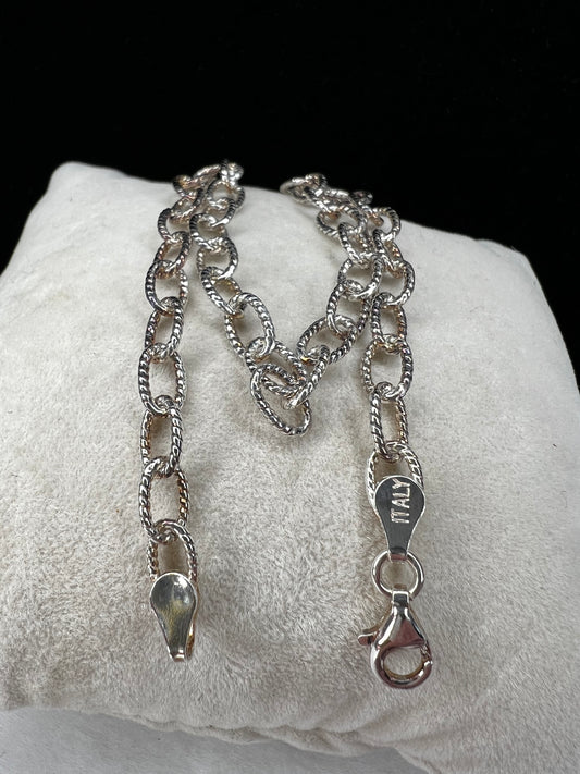 This sterling silver bracelet is designed with oval twisted chain links, which provides more shine and movement.