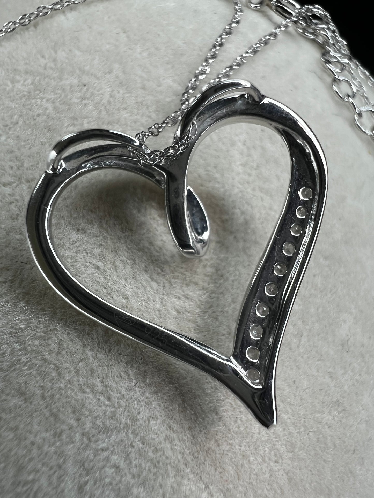 This delicate sterling silver chain holds a beautiful sterling heart pendant, accented with sparkling diamonds along one side. Perfect for adding a touch of elegance to any outfit.