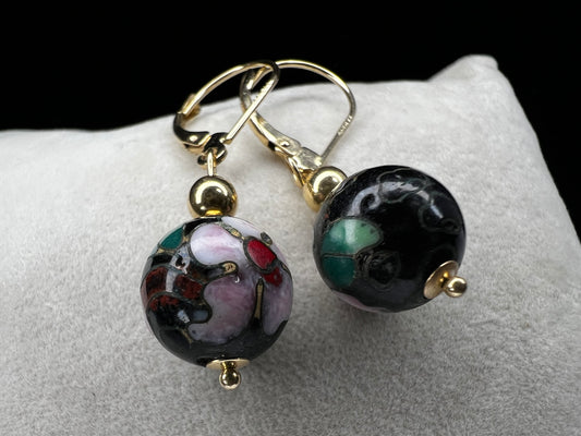 This is a beautiful pair of earrings. They feature cloisonné beads with pink flowers and green leaves set against a black back background to make the flowers pop. Marked 585 (another term for 14 karat gold).