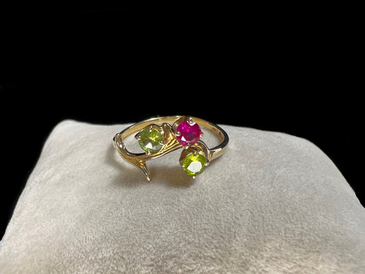 Crafted from 10 karat gold and designed to look like a tree branch, this ring is set with two spinels and a ruby.