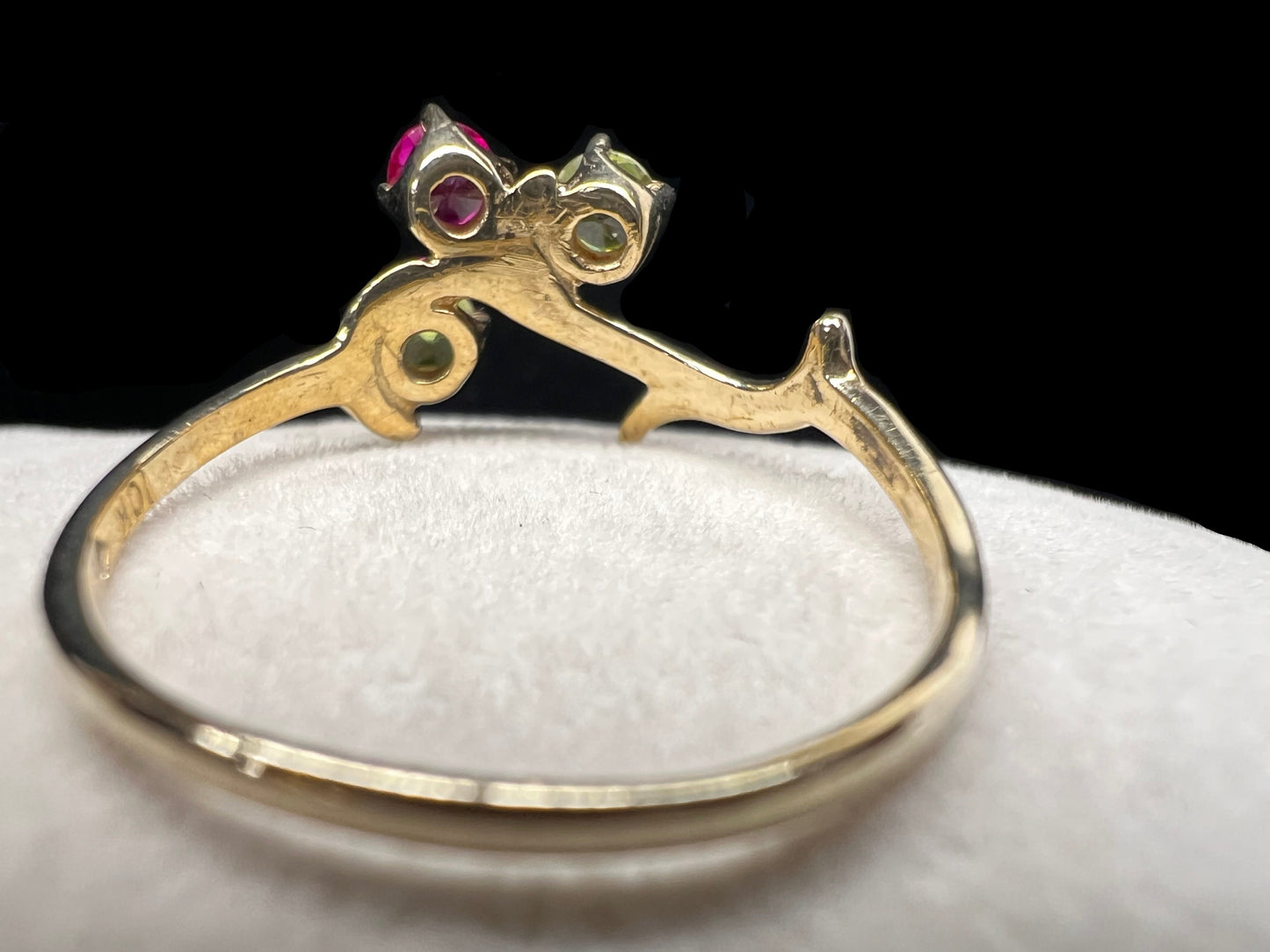 Crafted from 10 karat gold and designed to look like a tree branch, this ring is set with two spinels and a ruby.