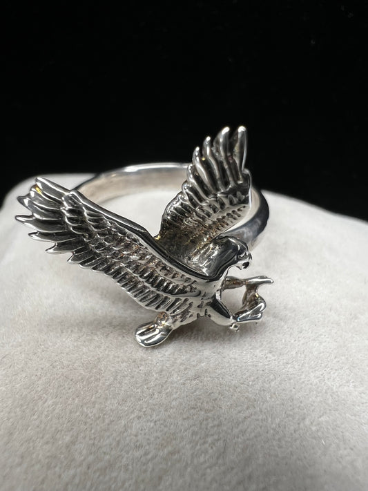 Upgrade your jewelry collection with this stunning sterling silver ring. Crafted with intricate detail, it features a swooping bird of prey in action.