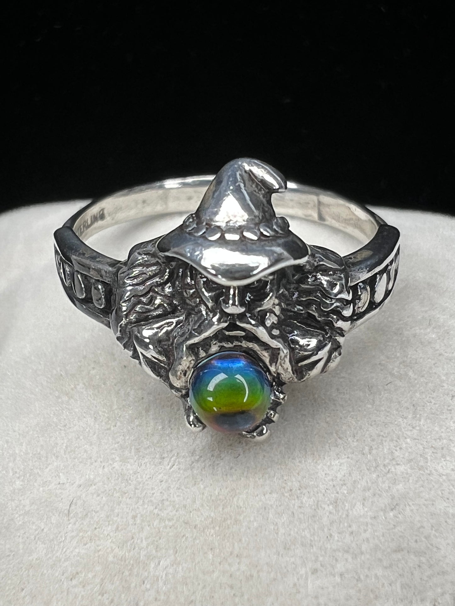 Add some magical mystique to your day with this sterling silver ring. It features a wizard and his crystal ball, which flashes multiple colors when moved in the light. This piece is marked with a copyright symbol and an S with a line through it (a dollar sign of sorts).