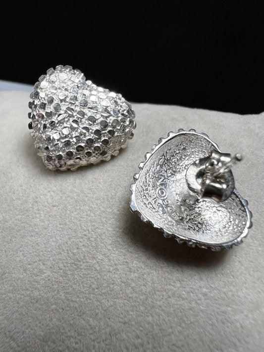 These bold heart-shaped sterling silver earrings are designed to look like a cluster of diamonds. It's a stunning look that will catch the light from every angle.