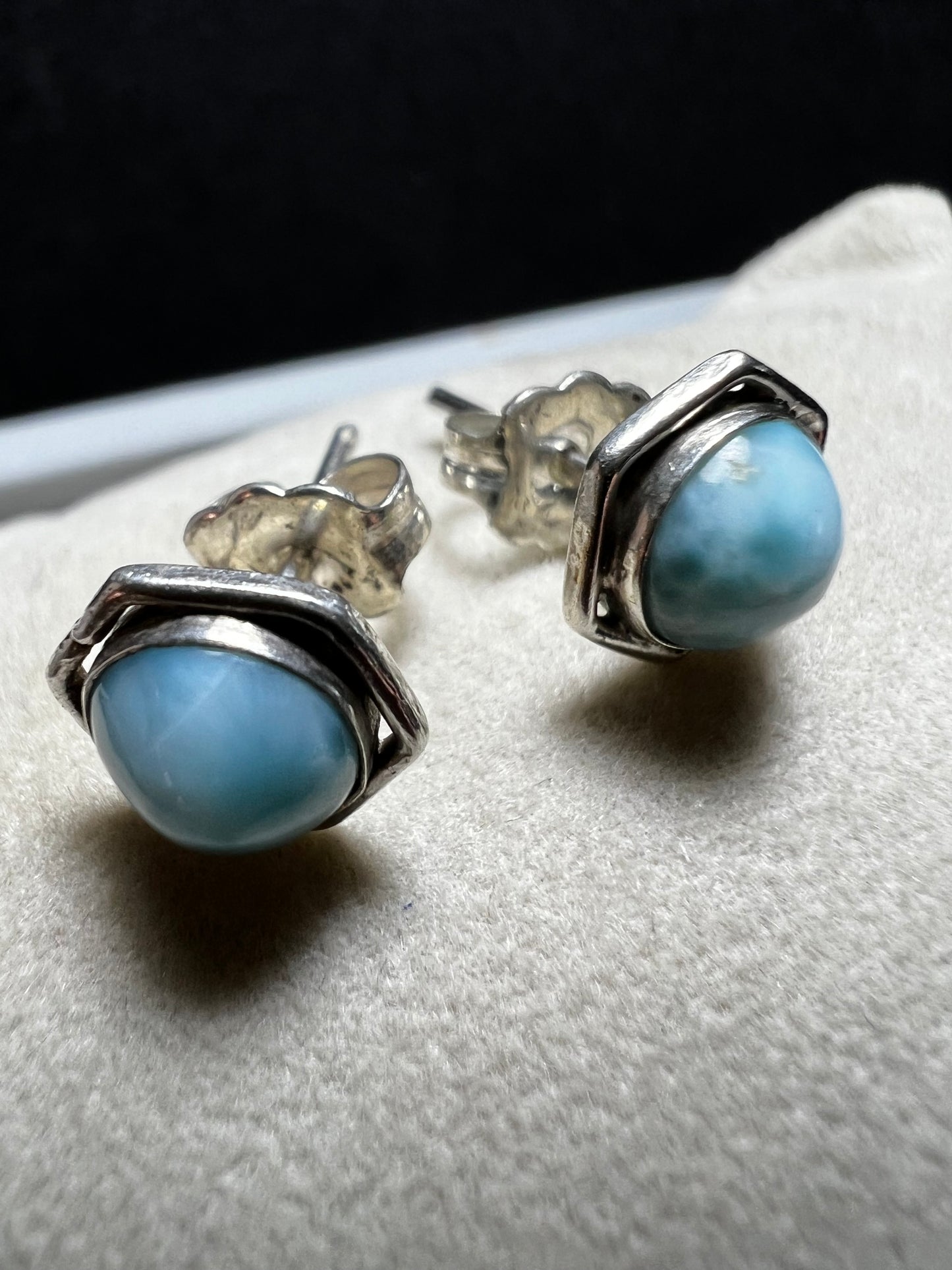 These sterling silver earrings feature natural larimar cabochons from the Dominican Republic set in a hexagon bezel, perfect for a touch of Caribbean charm.