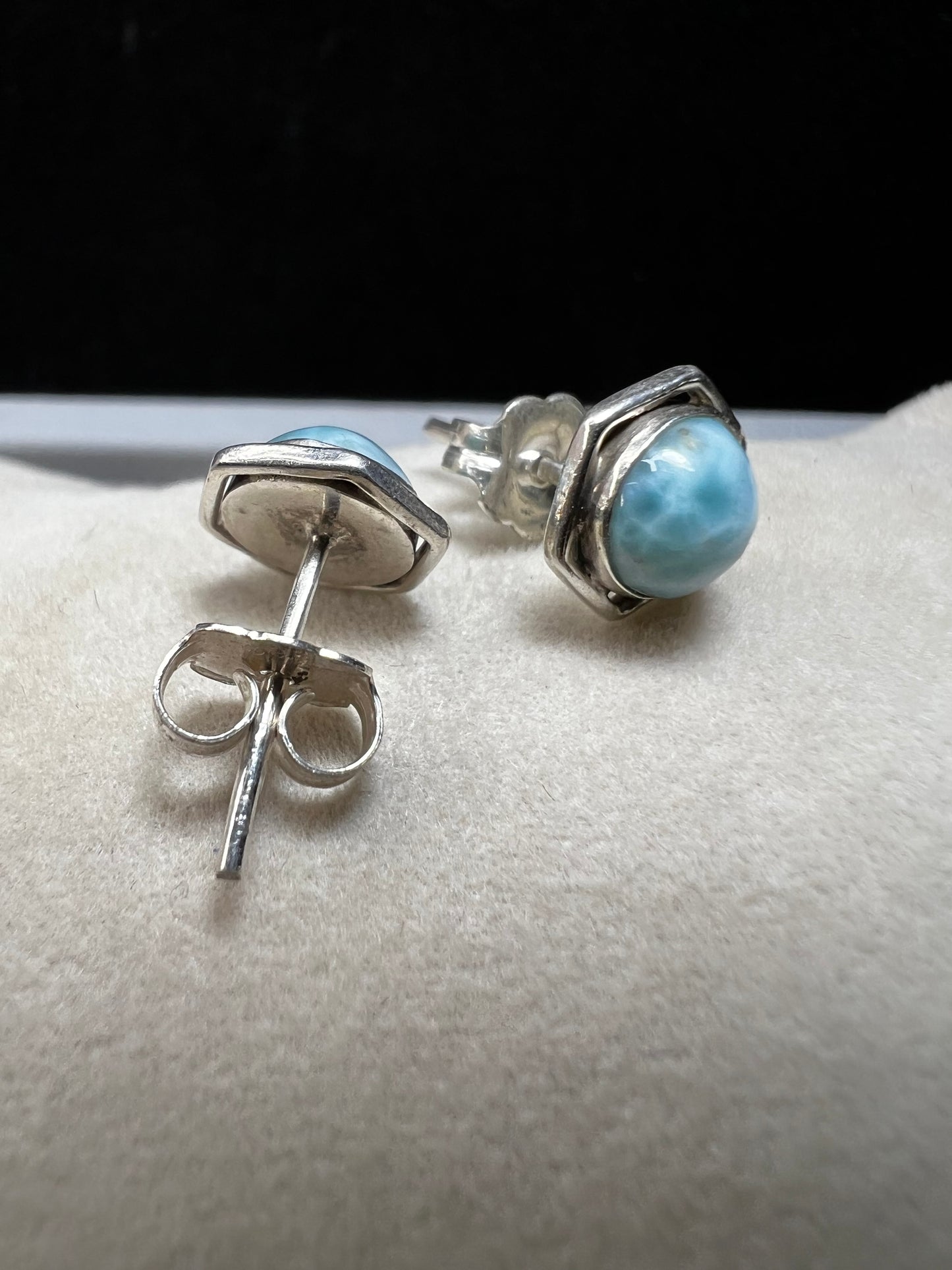 These sterling silver earrings feature natural larimar cabochons from the Dominican Republic set in a hexagon bezel, perfect for a touch of Caribbean charm.