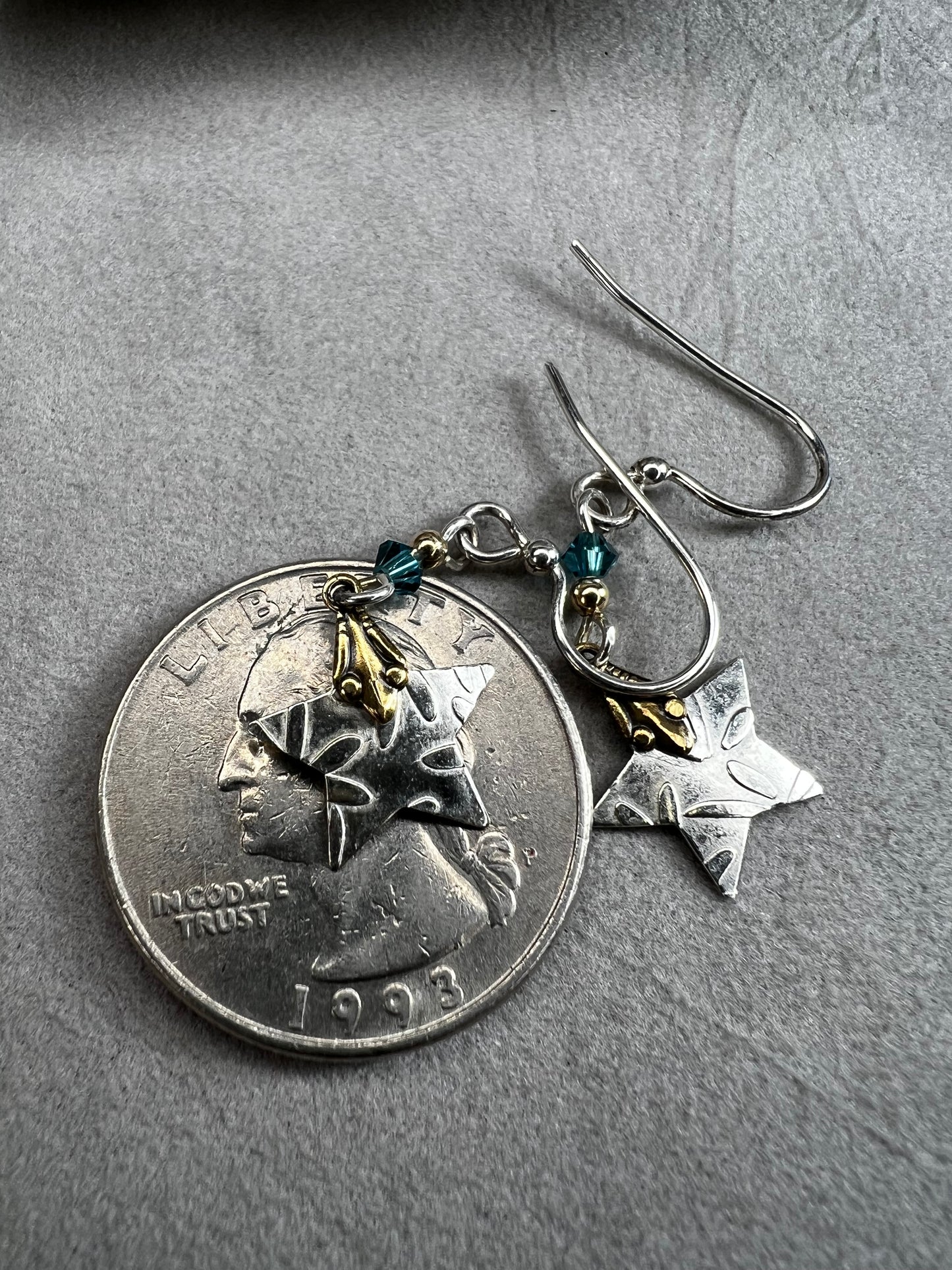 These sterling silver earrings are accented with 14-karat gold, creating a two-toned design as the stars dance in the light.