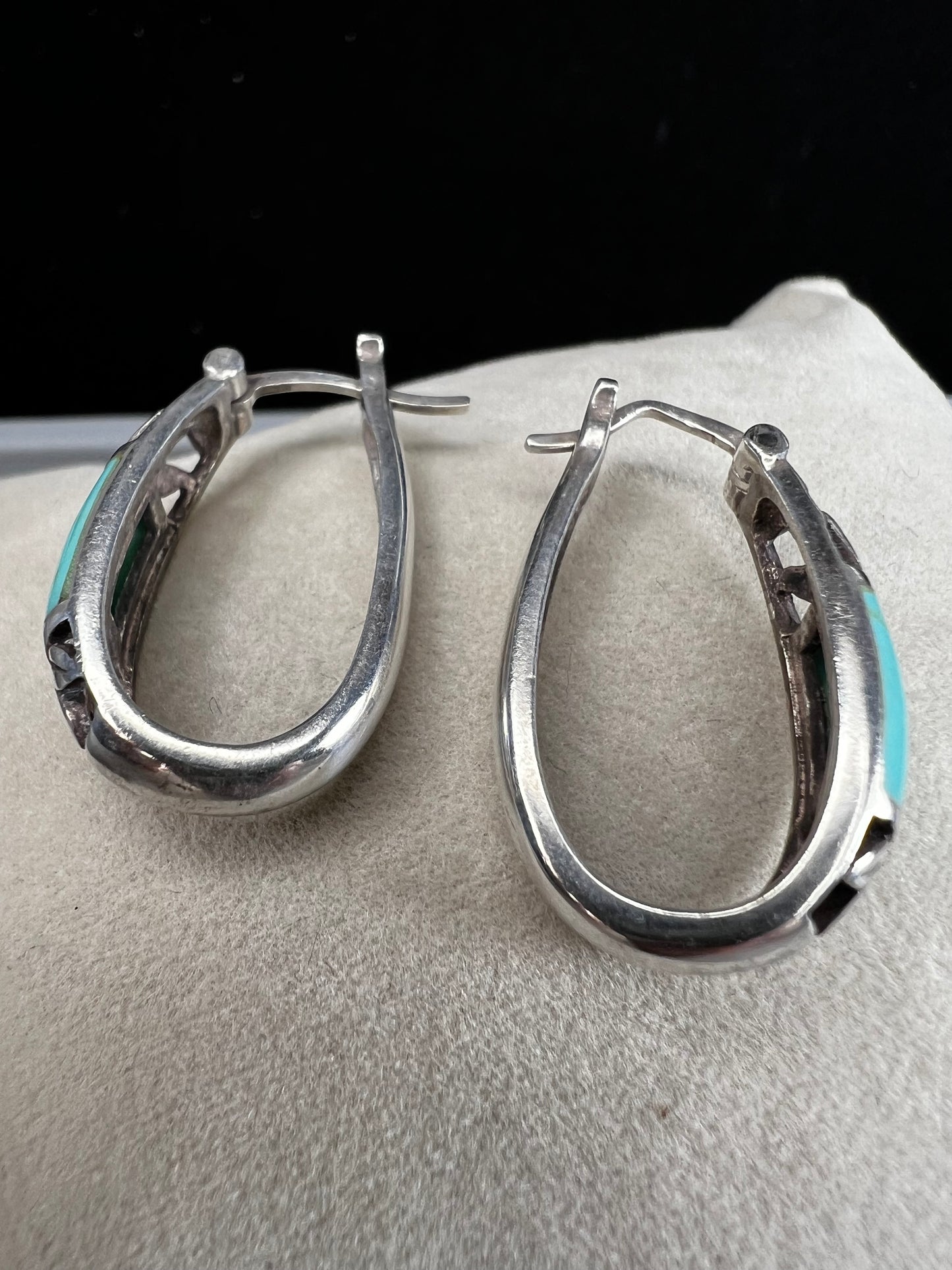 These vintage sterling silver earrings feature an openwork design accented with turquoise stones, offering a timeless vintage look.