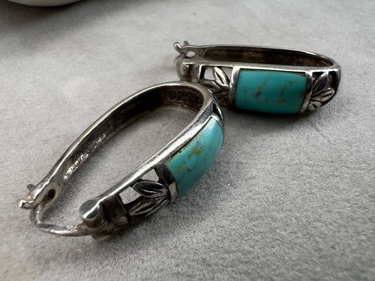 These vintage sterling silver earrings feature an openwork design accented with turquoise stones, offering a timeless vintage look.