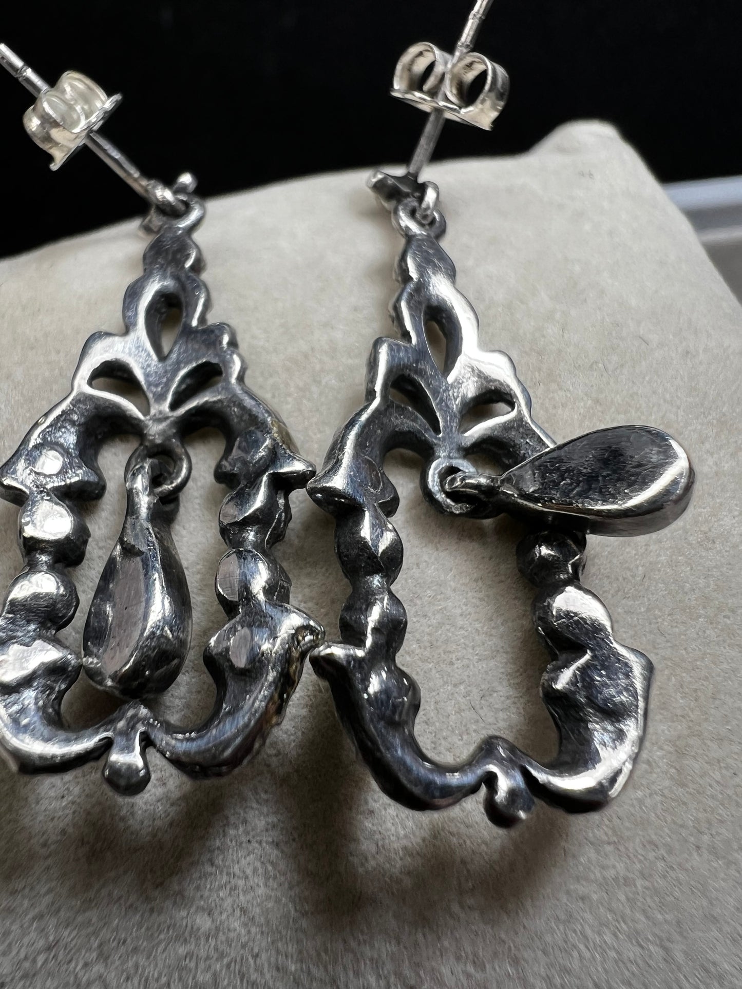 These sterling silver earrings shimmer with marcasite accents and showcase a dangling teardrop of onyx, adding timeless charm and subtle movement.