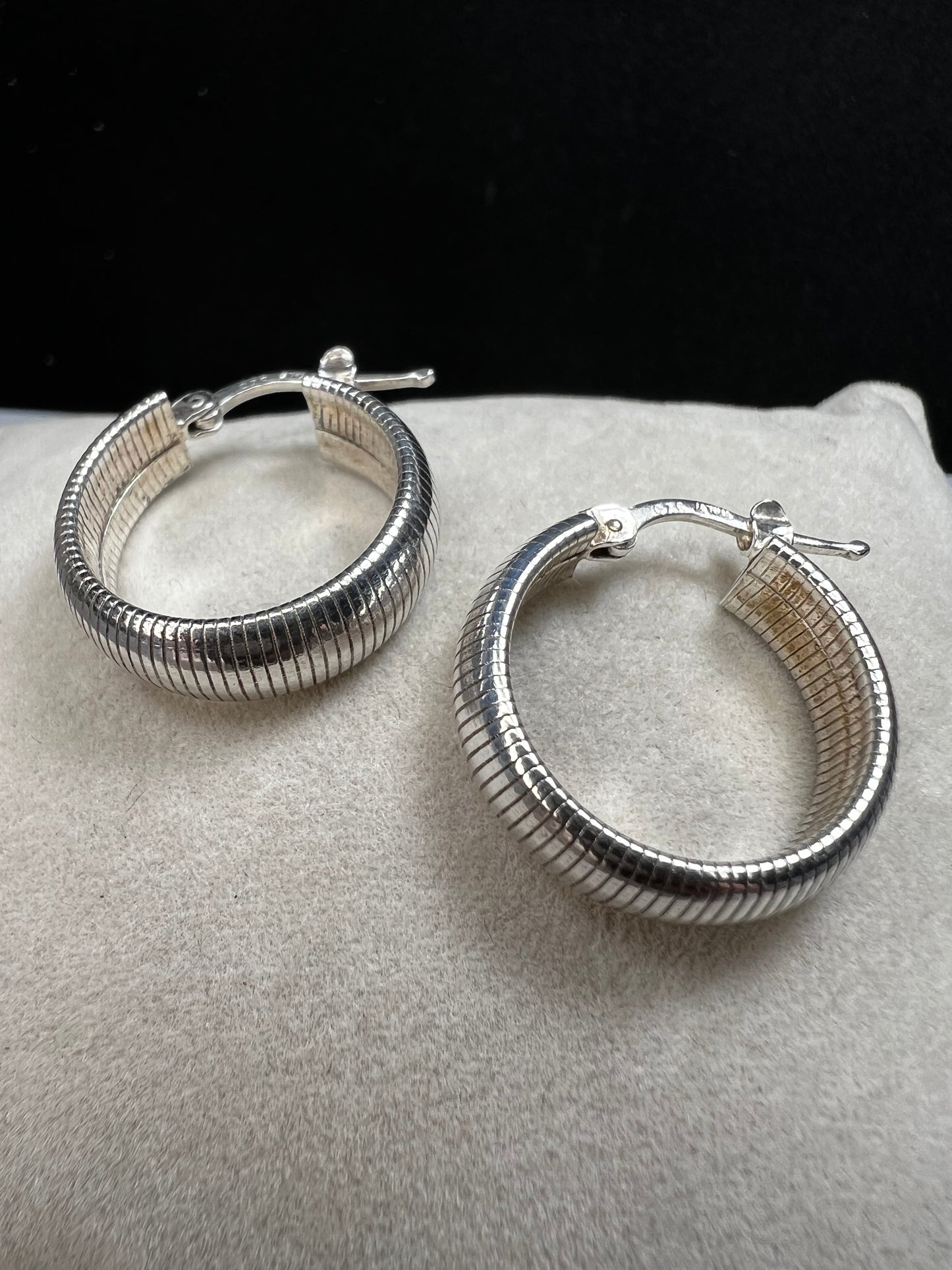 These sterling silver earrings feature a bold, domed design accented by horizontal ridges that catch the light beautifully.