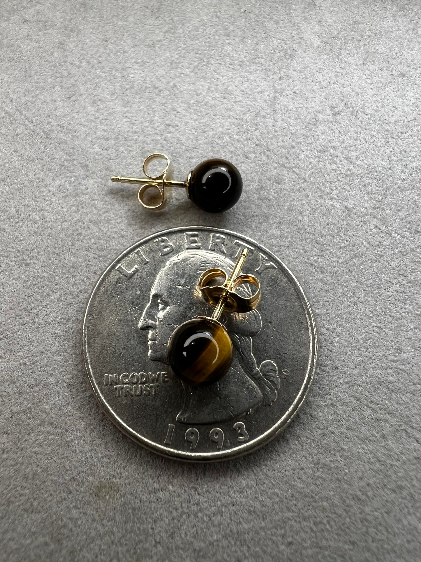 These earrings are crafted with 14 karat gold and feature a beautiful, petite tiger's eye stone.