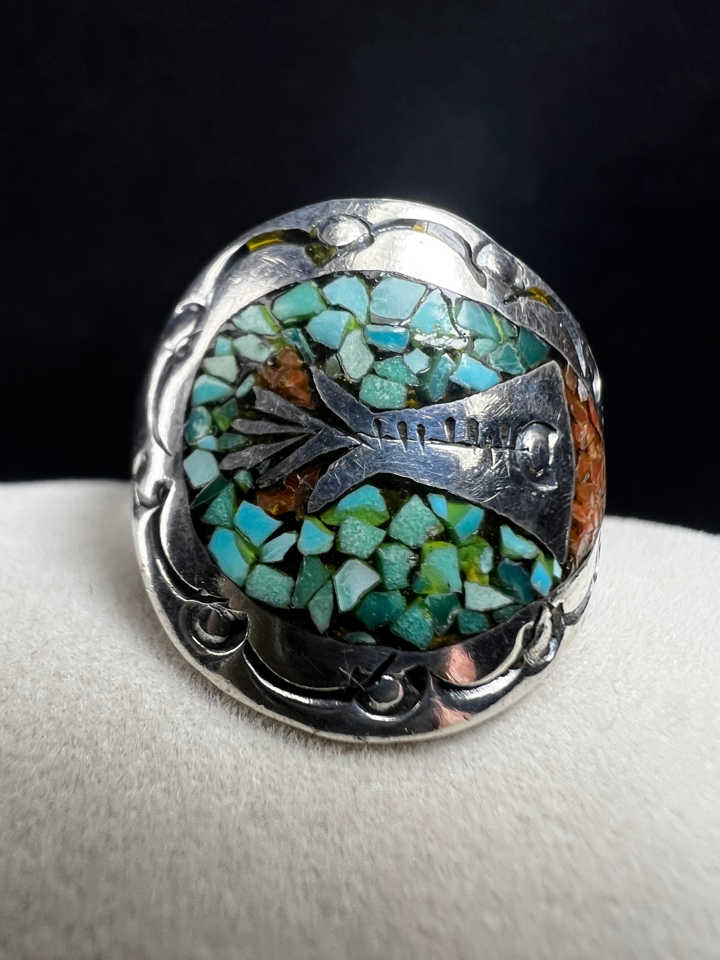 This expertly crafted vintage sterling silver ring, signed LB, showcases intricate detailing that captures timeless elegance. Accented with turquoise chips, it offers a distinctive and striking look, perfect for collectors or anyone seeking a unique piece with authentic vintage charm.