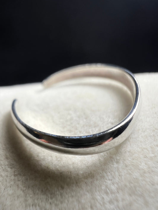 This sterling silver open band toe ring offers a simple, elegant design that adds a subtle shine to your foot, perfect for wearing at the beach or poolside. Its minimalist style ensures versatile wear while providing a touch of refined sparkle.