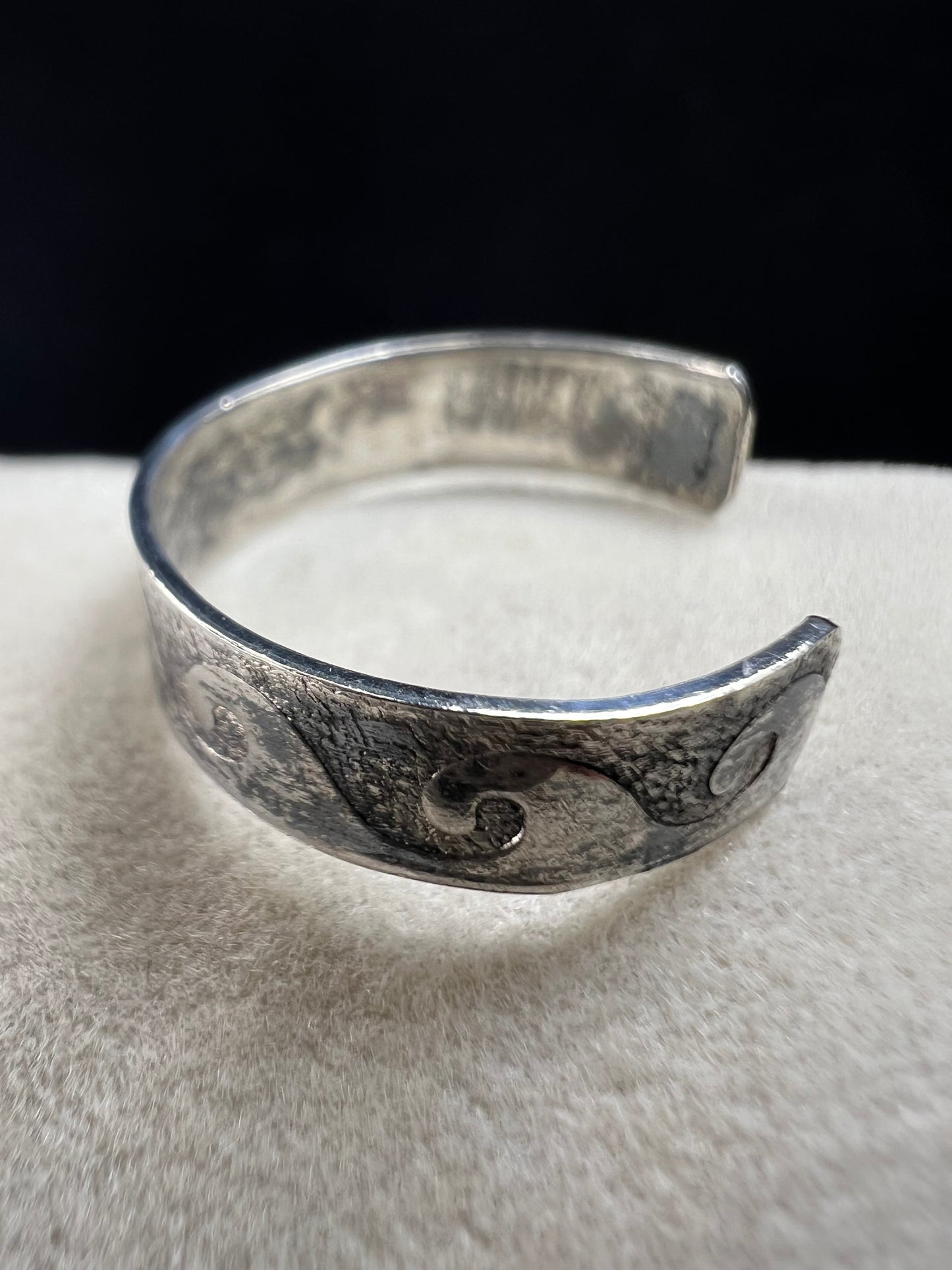 This vintage sterling silver toe ring features an open band with a timeless wave design, ideal for beach enthusiasts. Its detailed craftsmanship captures the effortless spirit of the ocean, making it a refined accessory for seaside or casual wear.