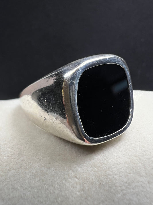 This vintage Avon ring combines sterling silver craftsmanship with a bold onyx centerpiece, designed to make a distinctive statement. Sized at 12.5, its unisex design suits both men and women seeking a timeless accessory with elegant presence.