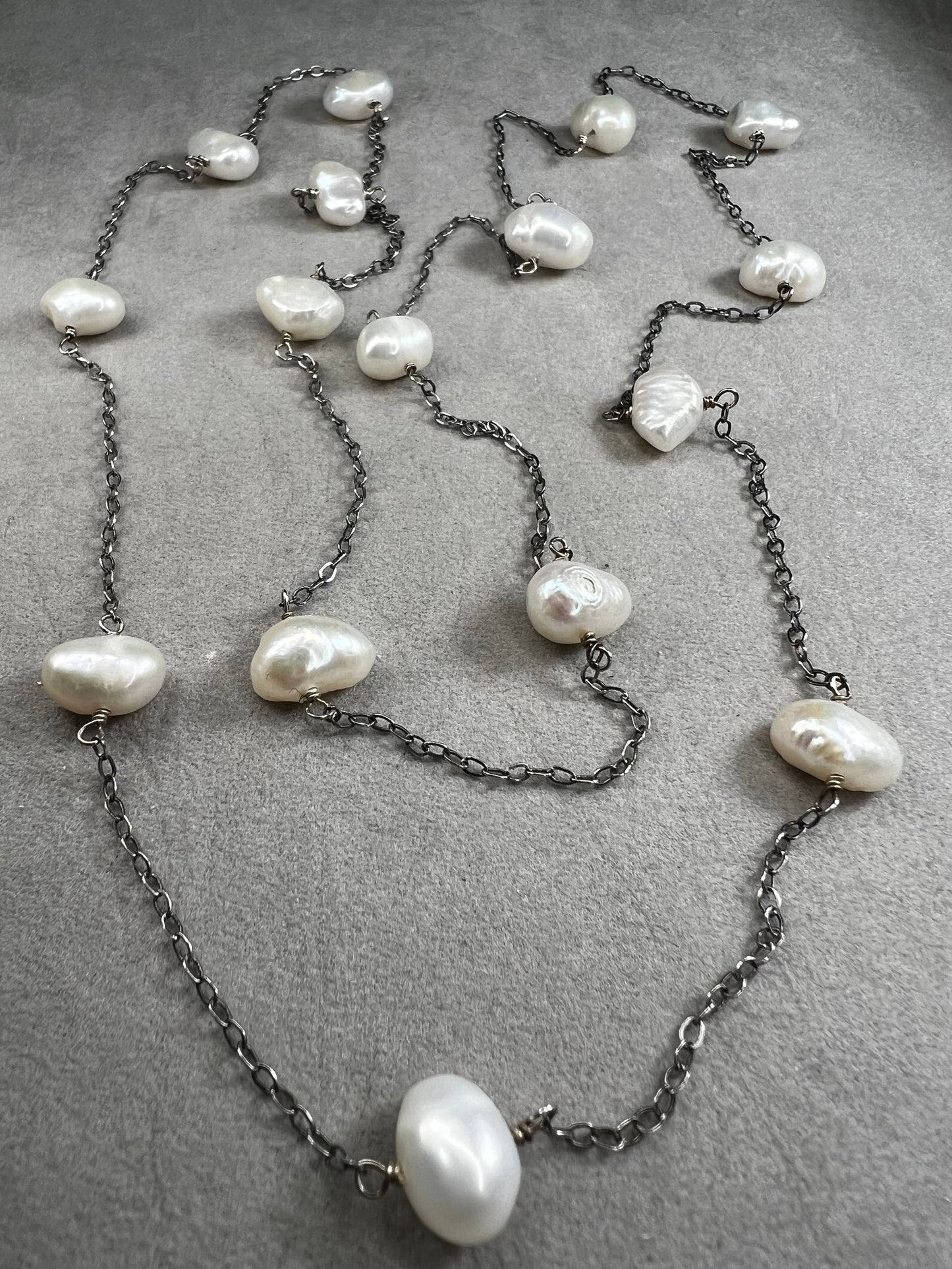 This 34-inch sterling silver chain is accented with baroque pearls spaced a few inches apart. Designed without a clasp, it slips easily over your head for effortless wear.