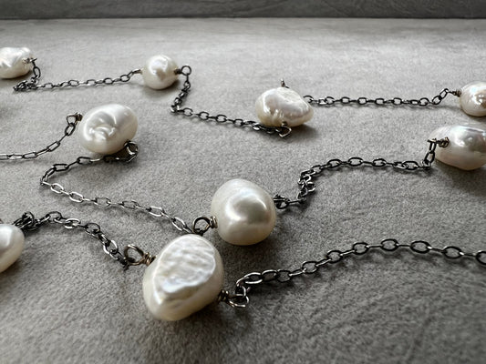 This 34-inch sterling silver chain is accented with baroque pearls spaced a few inches apart. Designed without a clasp, it slips easily over your head for effortless wear.