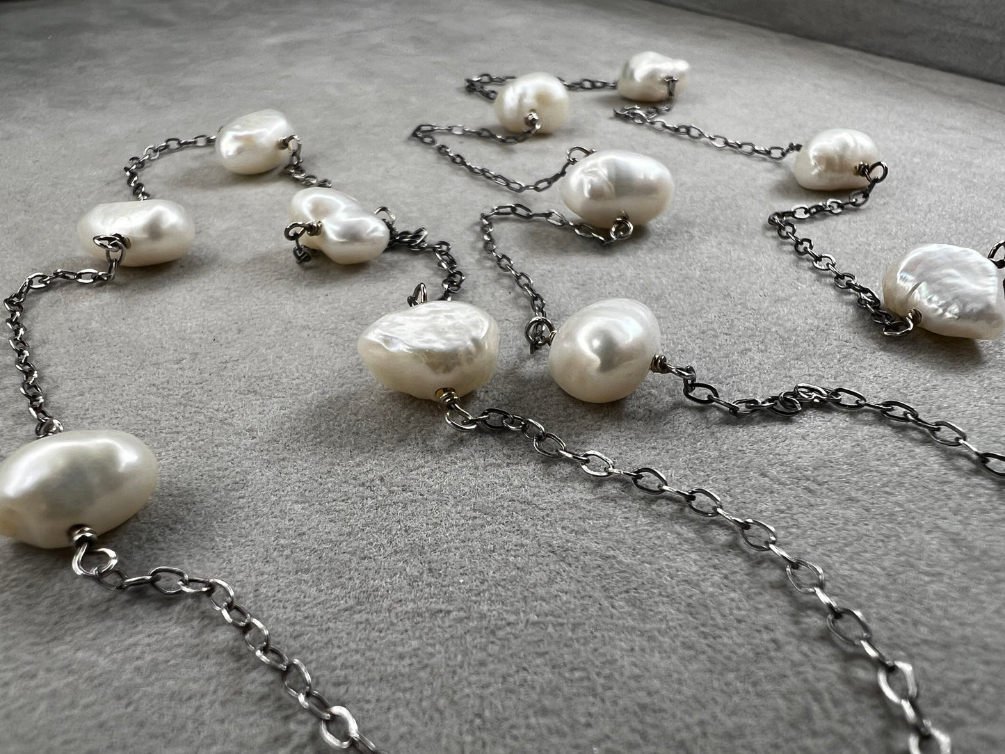 This 34-inch sterling silver chain is accented with baroque pearls spaced a few inches apart. Designed without a clasp, it slips easily over your head for effortless wear.