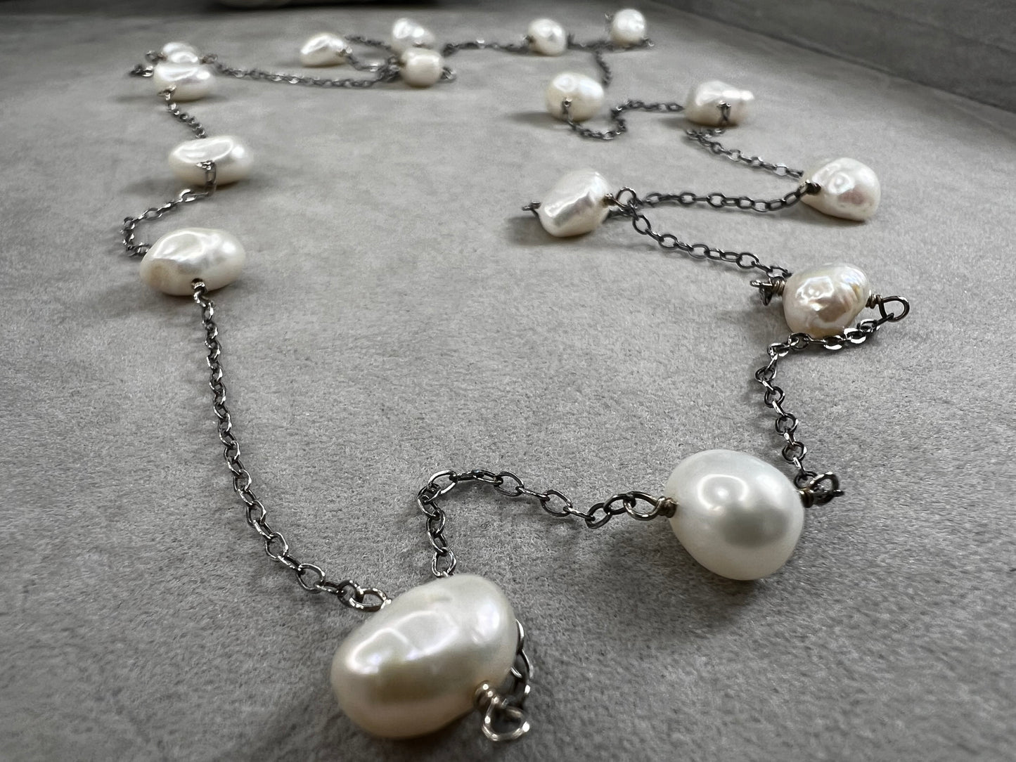 This 34-inch sterling silver chain is accented with baroque pearls spaced a few inches apart. Designed without a clasp, it slips easily over your head for effortless wear.