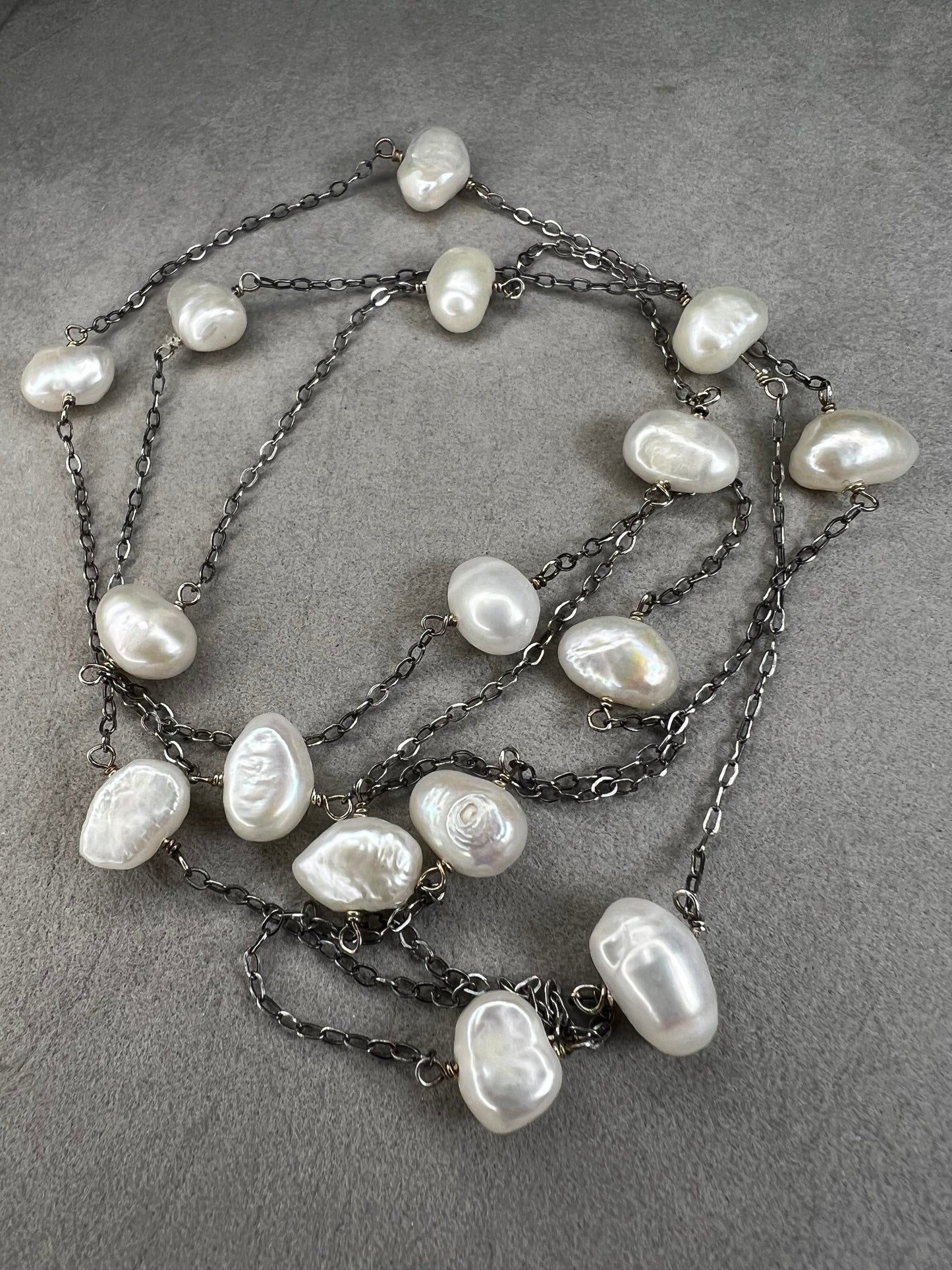 This 34-inch sterling silver chain is accented with baroque pearls spaced a few inches apart. Designed without a clasp, it slips easily over your head for effortless wear.