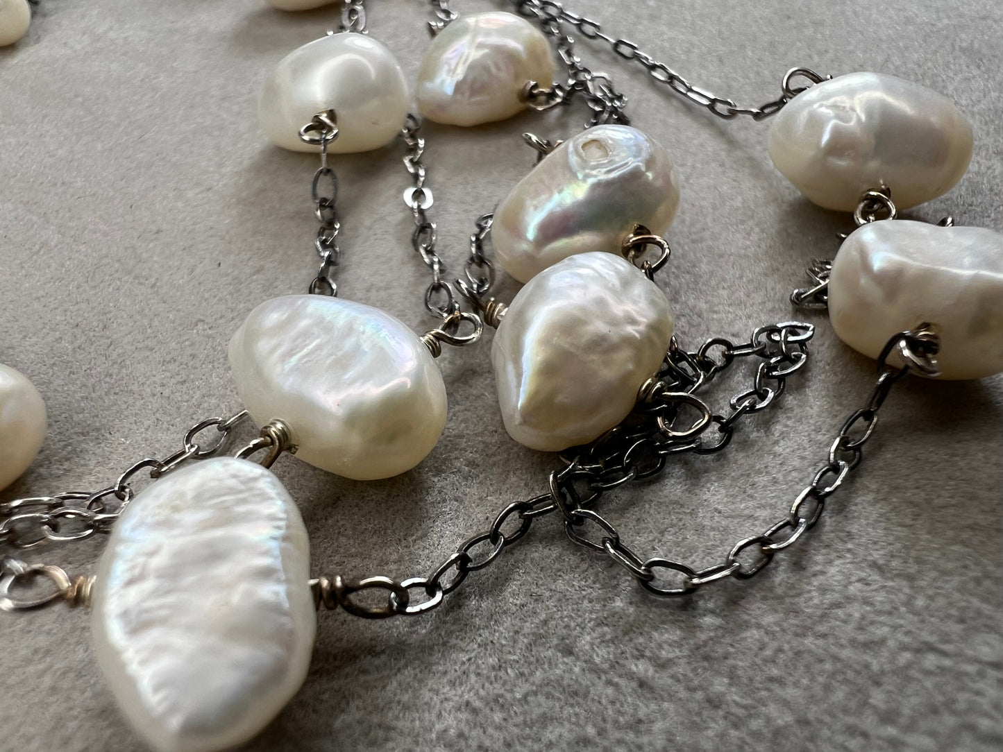 This 34-inch sterling silver chain is accented with baroque pearls spaced a few inches apart. Designed without a clasp, it slips easily over your head for effortless wear.