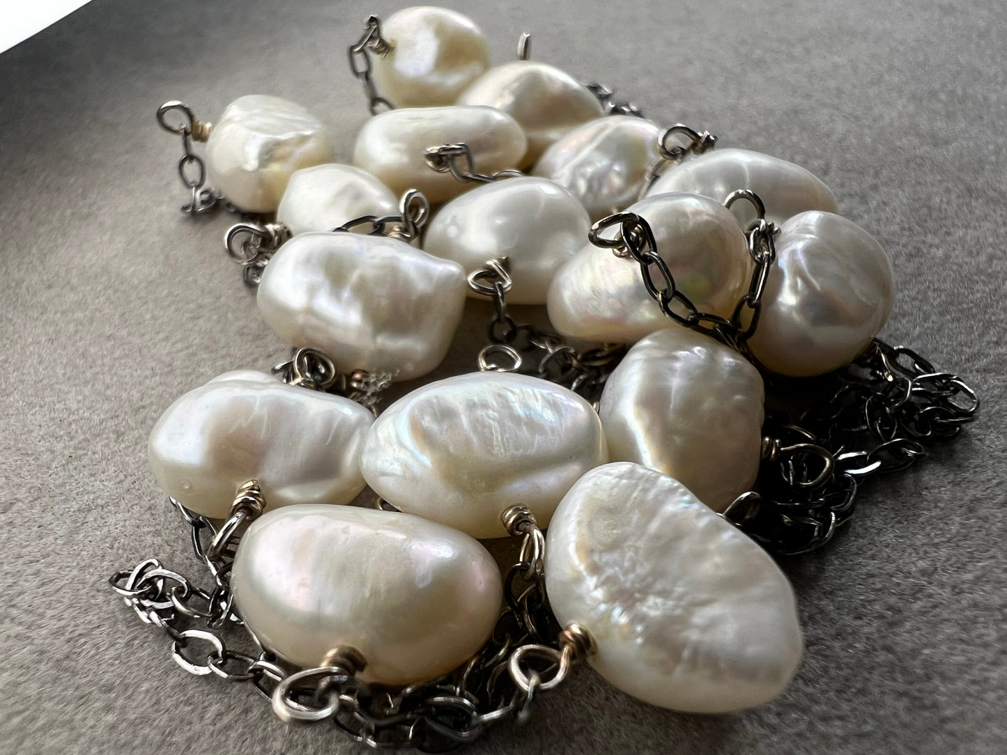 This 34-inch sterling silver chain is accented with baroque pearls spaced a few inches apart. Designed without a clasp, it slips easily over your head for effortless wear.