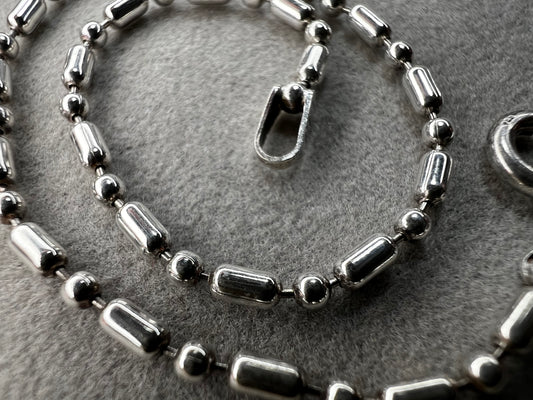 This sterling silver bracelet features an expertly crafted bead-and-tube link design, offering a distinctive alternative to traditional chains.