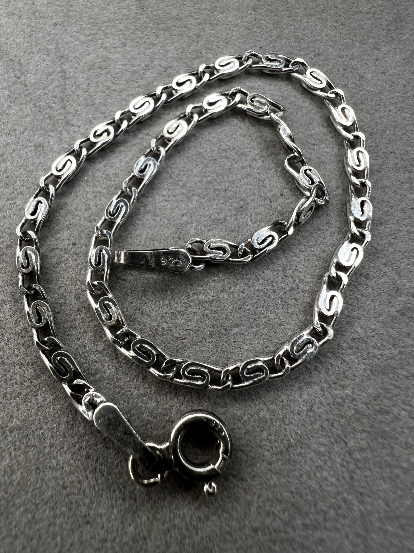This sterling silver bracelet showcases a refined scroll link design, distinguishing it from standard chain styles. Expertly crafted for both durability and elegance, it offers a sophisticated accessory that enhances any wardrobe.