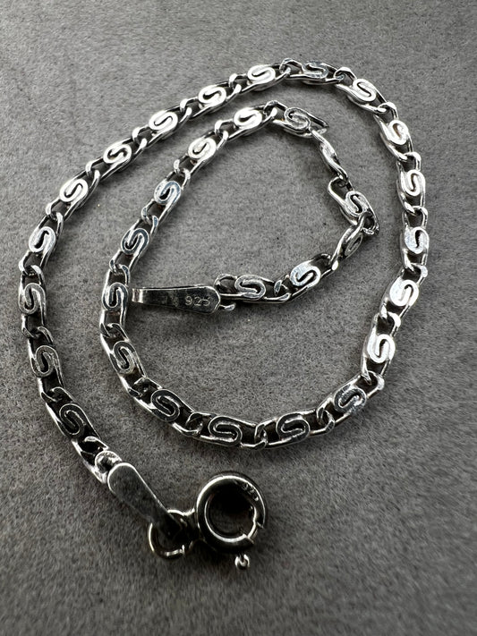 This sterling silver bracelet showcases a refined scroll link design, distinguishing it from standard chain styles. Expertly crafted for both durability and elegance, it offers a sophisticated accessory that enhances any wardrobe.