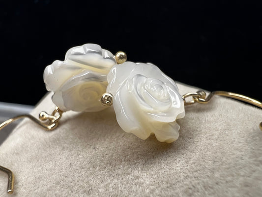 This stunning pair of earrings features a mother of pearl rose on each with gold washed sterling silver.