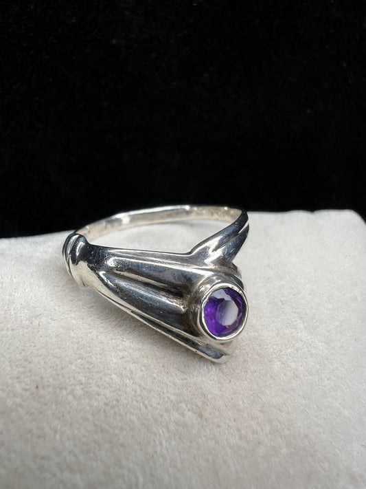 Add some individuality to your outfit with this sterling silver ring. Its unique design features an amethyst front and center.