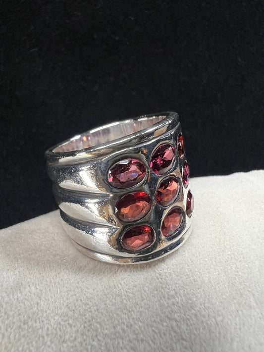 This striking vintage sterling silver ring features 12 garnets with a subtle purple tint, creating a bold and elegant statement piece. Please note that the ring has some scuffs, including a larger mark on the back, which you can see in the photos.