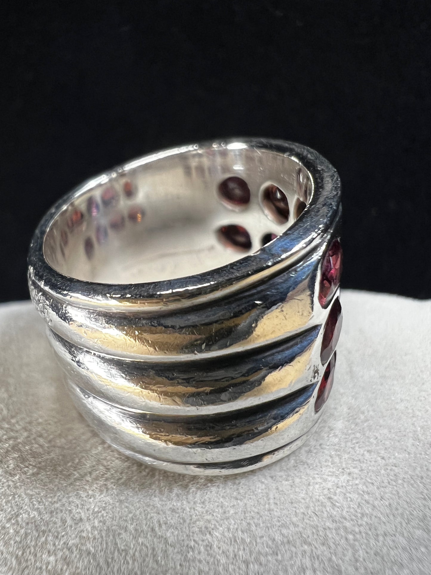 This striking vintage sterling silver ring features 12 garnets with a subtle purple tint, creating a bold and elegant statement piece. Please note that the ring has some scuffs, including a larger mark on the back, which you can see in the photos.