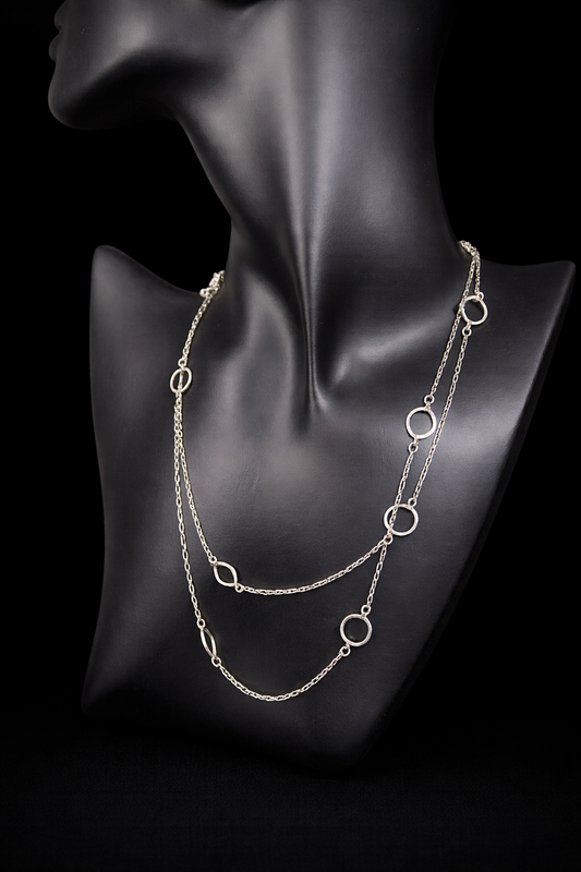 This long sterling silver necklace is designed with intermittent geometric links along the length of the chain. Two of those large links feature a small diamond for a touch of flash in the light. At 34 inches, this can be wrapped twice for a layered look, or it can be worn long. Made by Silpada.